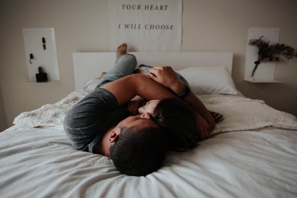 couple lying in bed hugging each other tightly