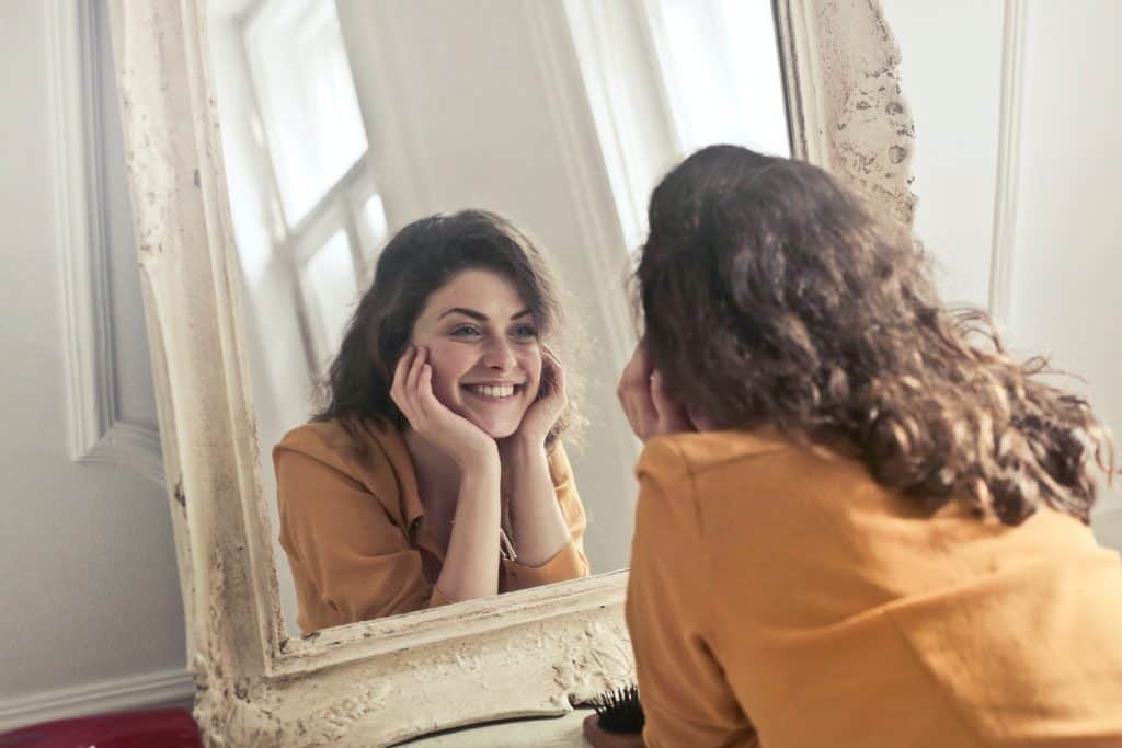 a woman in front of the mirror smiling